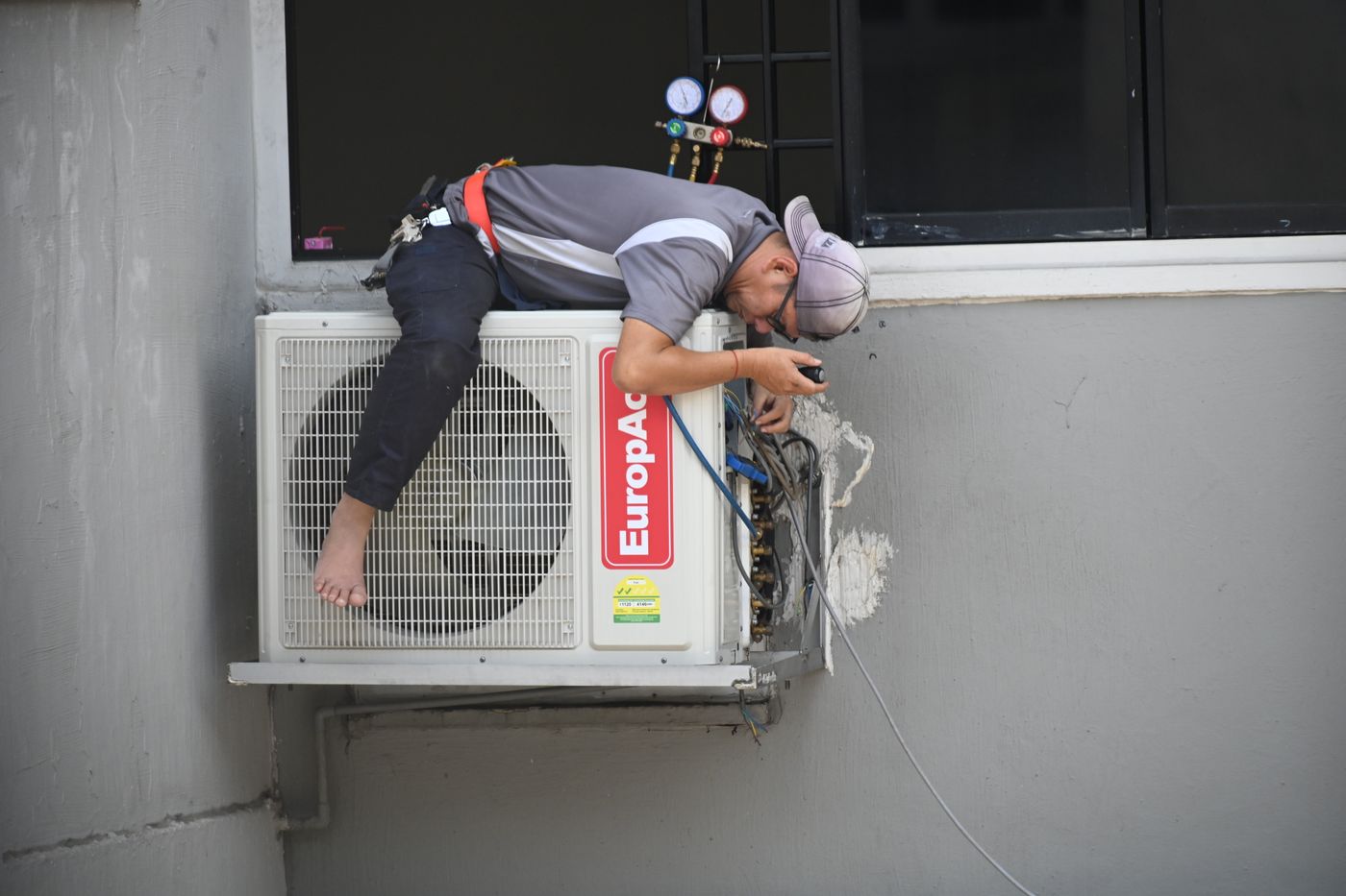 Teknisi membersihkan unit indoor AC
