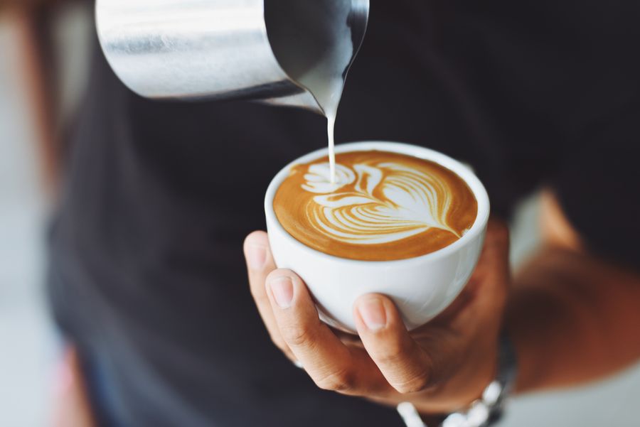 Barista menuang susu membentuk latte art di Ruang Seduh