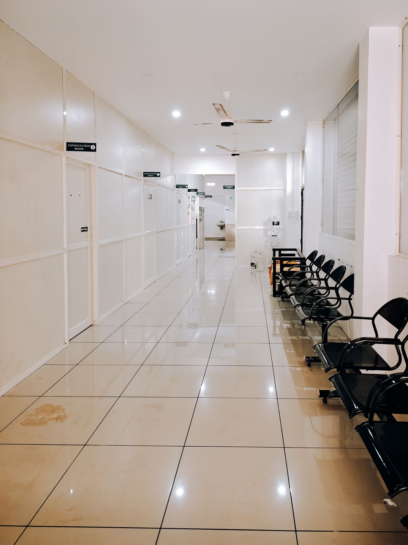 Koridor klinik yang bersih dengan deretan kursi tunggu