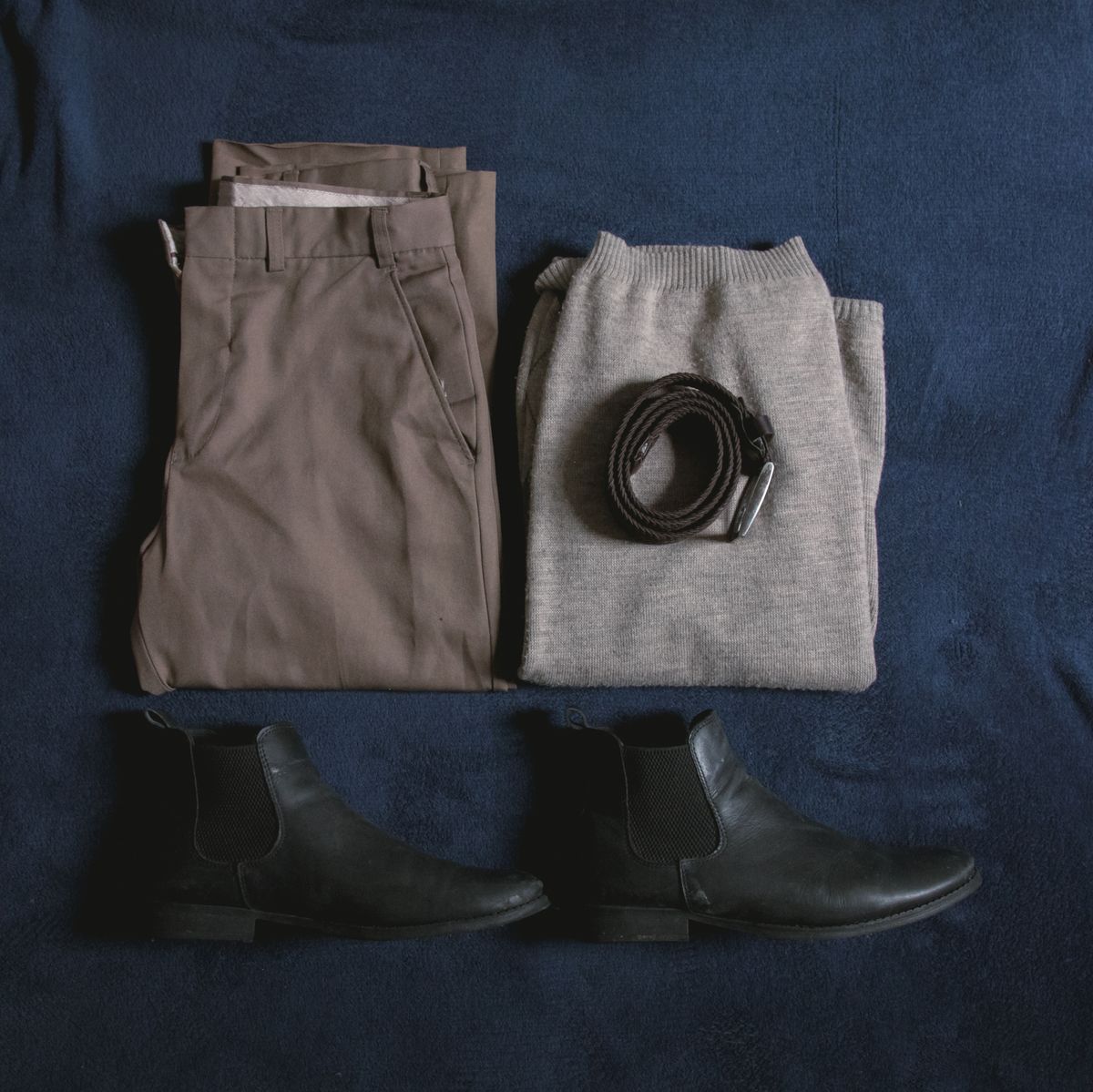 Celana chino dilipat dengan sweter rajut dan sepatu boots